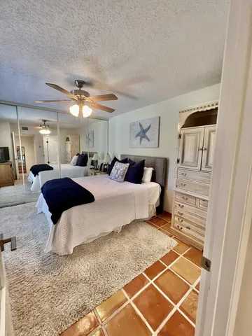 a large bedroom with a bed and a mirror on the dresser