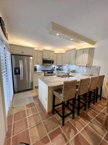 a kitchen with a sink a counter and chairs