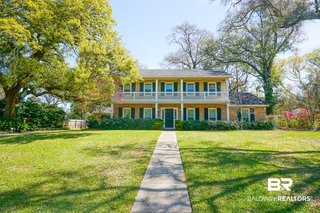 View of front of home featuring a front yard and brick siding