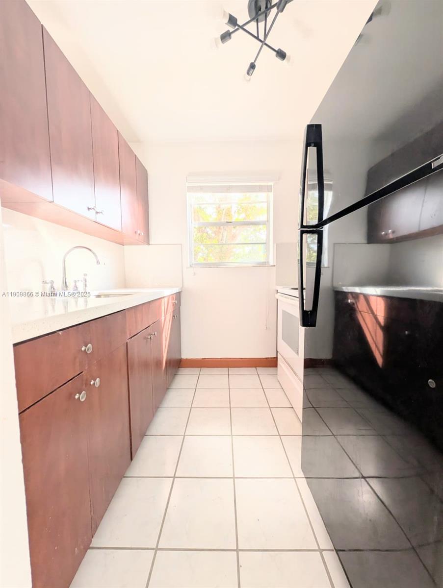 1551 Northeast 8th Street, Unit 5 Homestead, FL 33033 - Photo 4 of 8 a kitchen with a sink a counter and cabinets