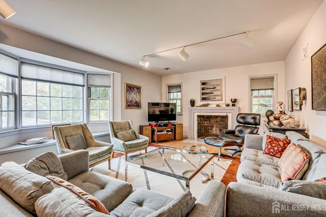a living room with furniture a flat screen tv and a dining table