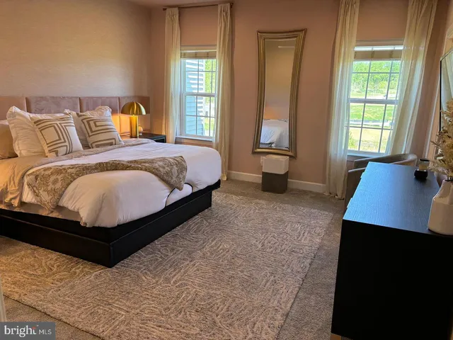 a bed sitting in a bedroom next to a window