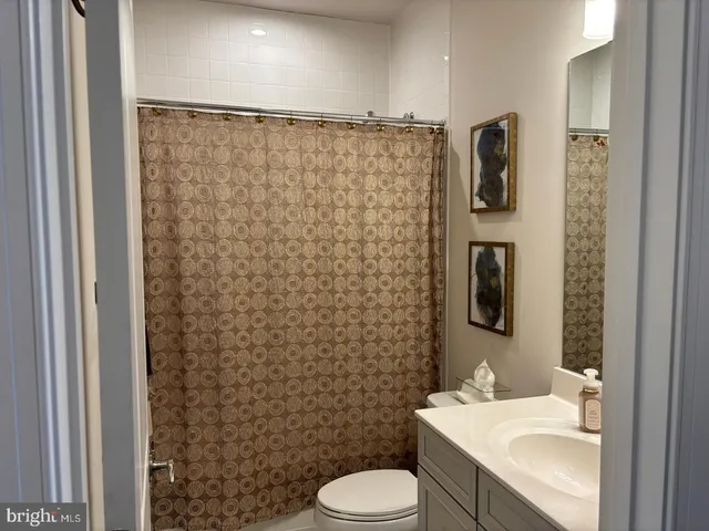 a bathroom with a sink a toilet and shower curtain