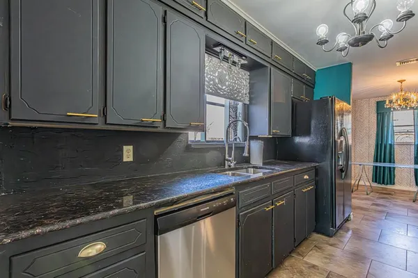 a kitchen with stainless steel appliances granite countertop a sink a refrigerator and a microwave