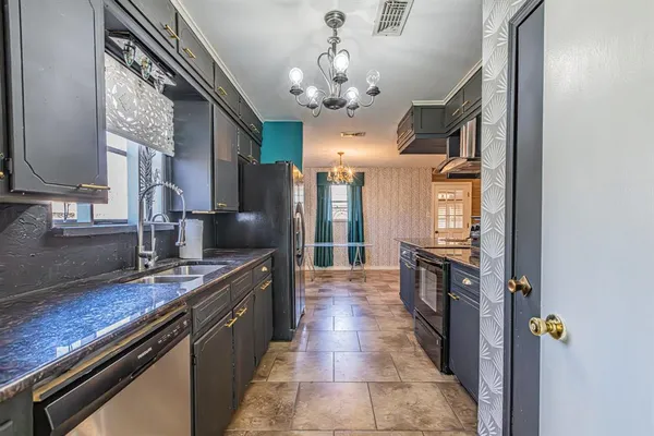 a kitchen with stainless steel appliances granite countertop a sink and a refrigerator