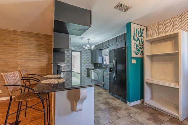 a kitchen with stainless steel appliances kitchen island granite countertop a refrigerator and a stove