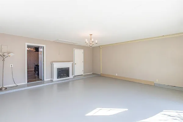 an empty room with a fireplace and window