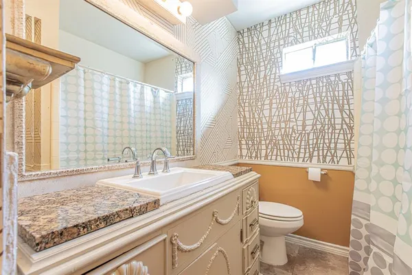 an empty room with a chandelier fan and windows