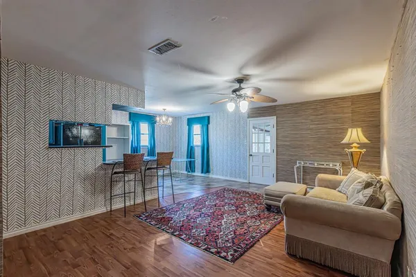 a living room with furniture and a wooden floor