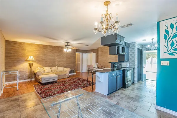 a living room with granite countertop furniture and a chandelier
