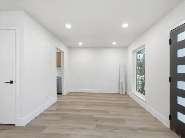 an empty room with wooden floor and a ceiling fan