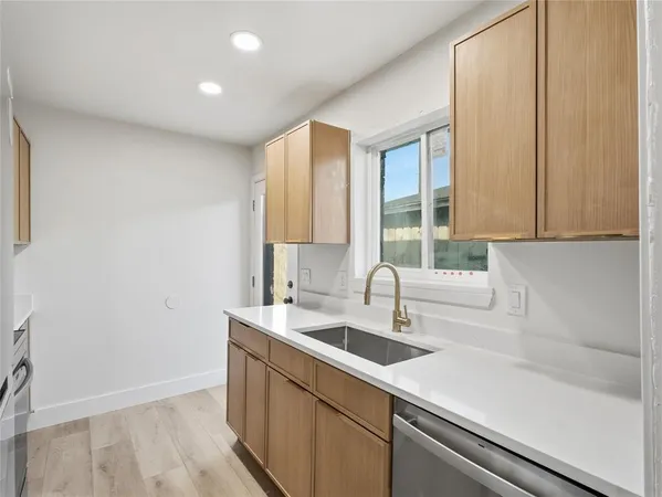 a kitchen with stainless steel appliances a refrigerator sink and microwave