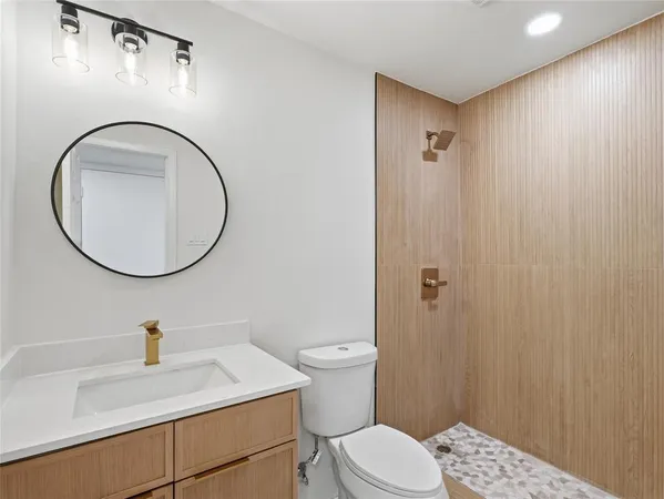 a bathroom with a sink a toilet and shower