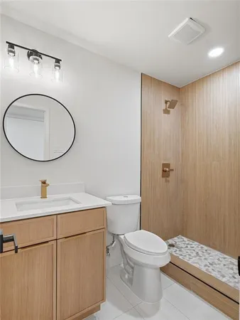 a bathroom with a sink a toilet and shower