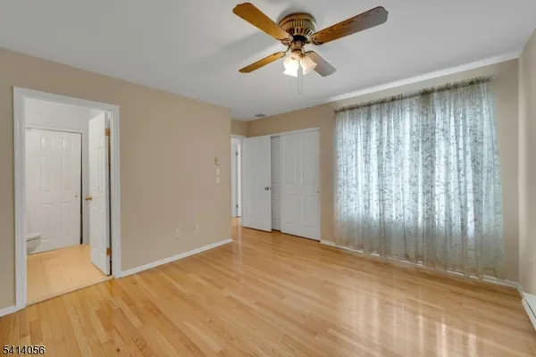 an empty room with a window and a fan