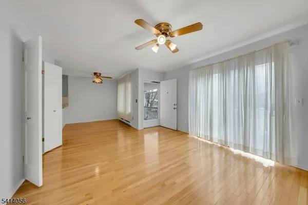 a view of an empty room and window and wooden floor