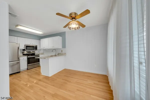 a kitchen with a refrigerator and white cabinets