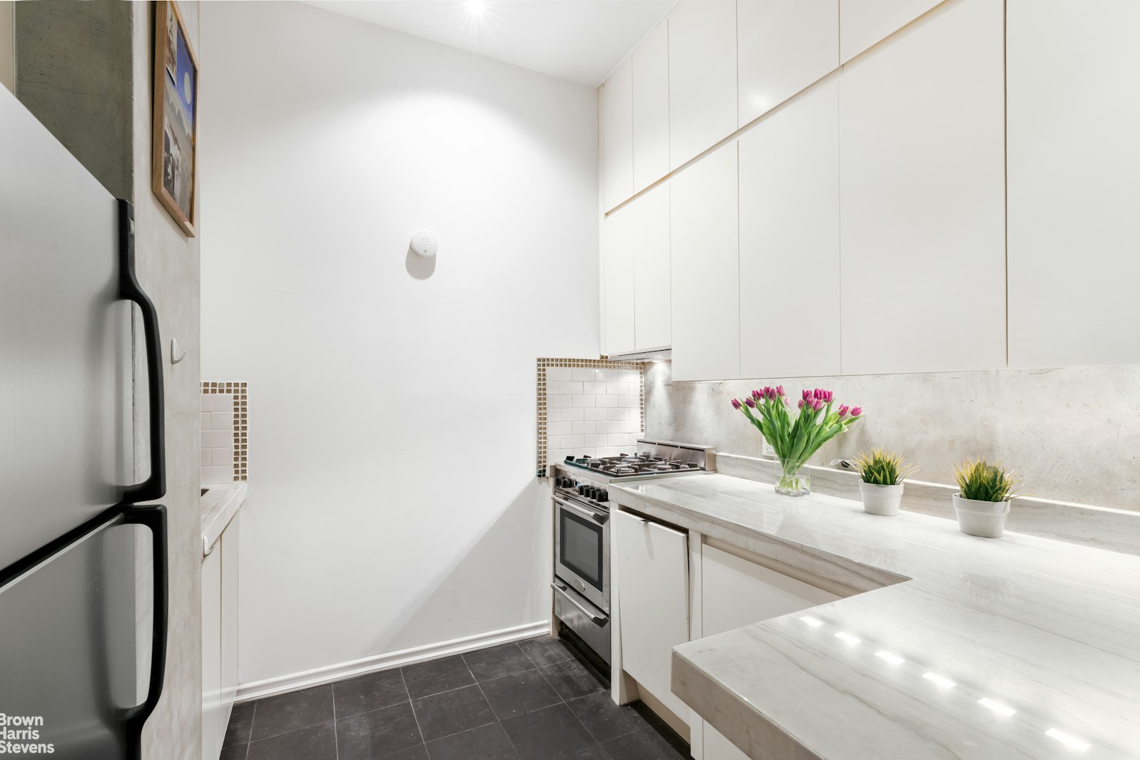 310 East 46th Street, Unit 4N Manhattan, NY 10017 - Photo 12 of 21 a living room with stainless steel appliances furniture a potted plant and a wooden floor
