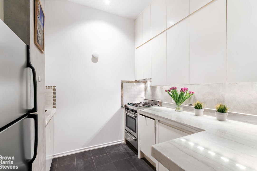 310 East 46th Street, Unit 4N Manhattan, NY 10017 - Photo 3 of 21 a living room with stainless steel appliances furniture a potted plant and a wooden floor