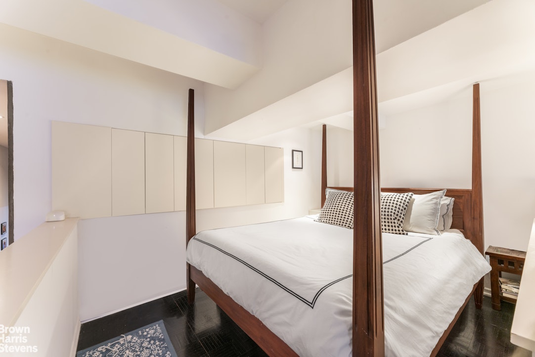 310 East 46th Street, Unit 4N Manhattan, NY 10017 - Photo 4 of 21 a bedroom with a bed and a night stand