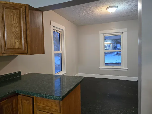 a kitchen with granite countertop cabinets and window