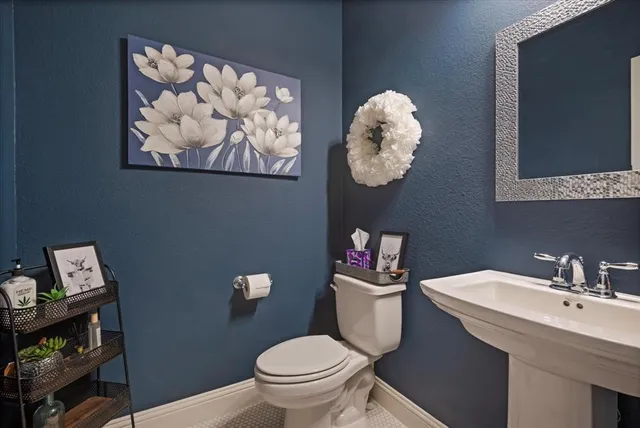 a bathroom with a toilet a sink and mirror