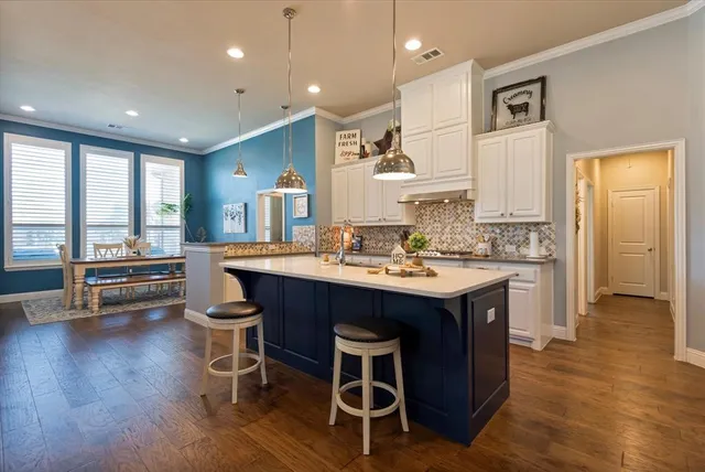 a kitchen with a sink appliances and wooden floor