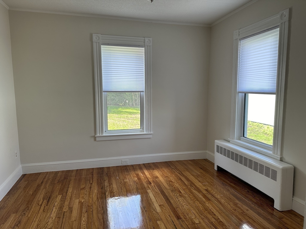 36 Cross Street, Unit 1 Winchester, MA 01890 - Photo 13 of 16 a view of an empty room with wooden floor and a window