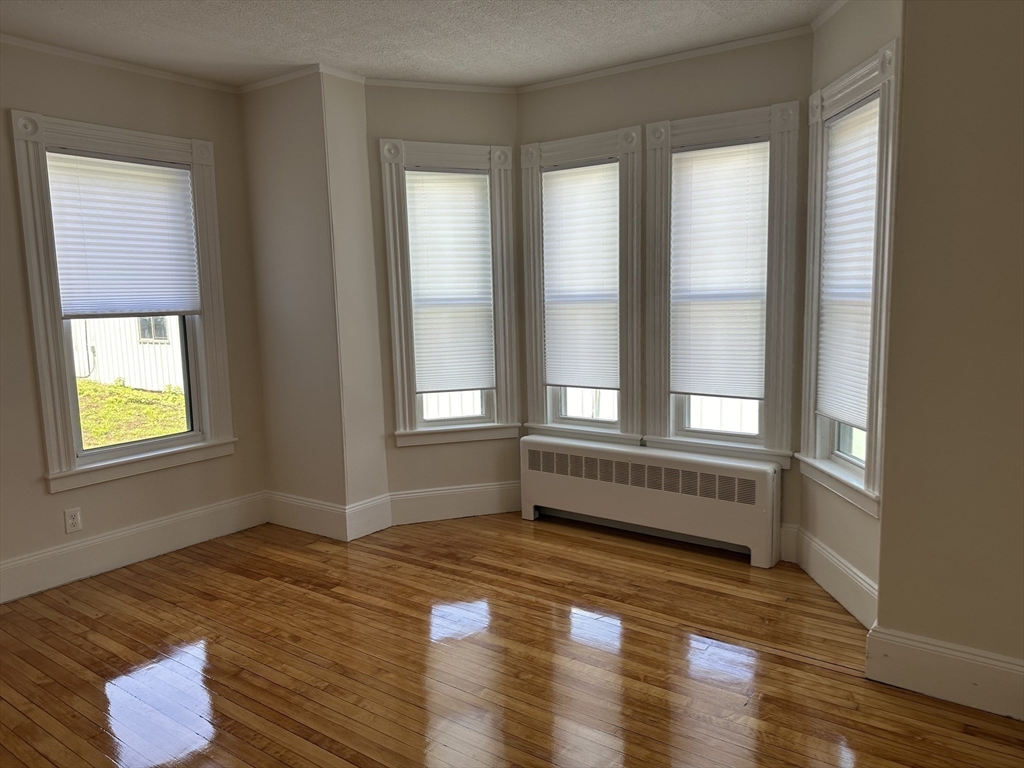 36 Cross Street, Unit 1 Winchester, MA 01890 - Photo 14 of 16 a view of an empty room with wooden floor and a window