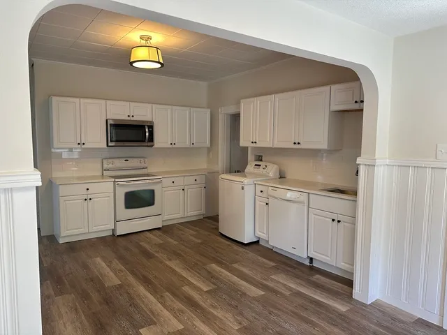 a kitchen with a sink cabinets and wooden floor