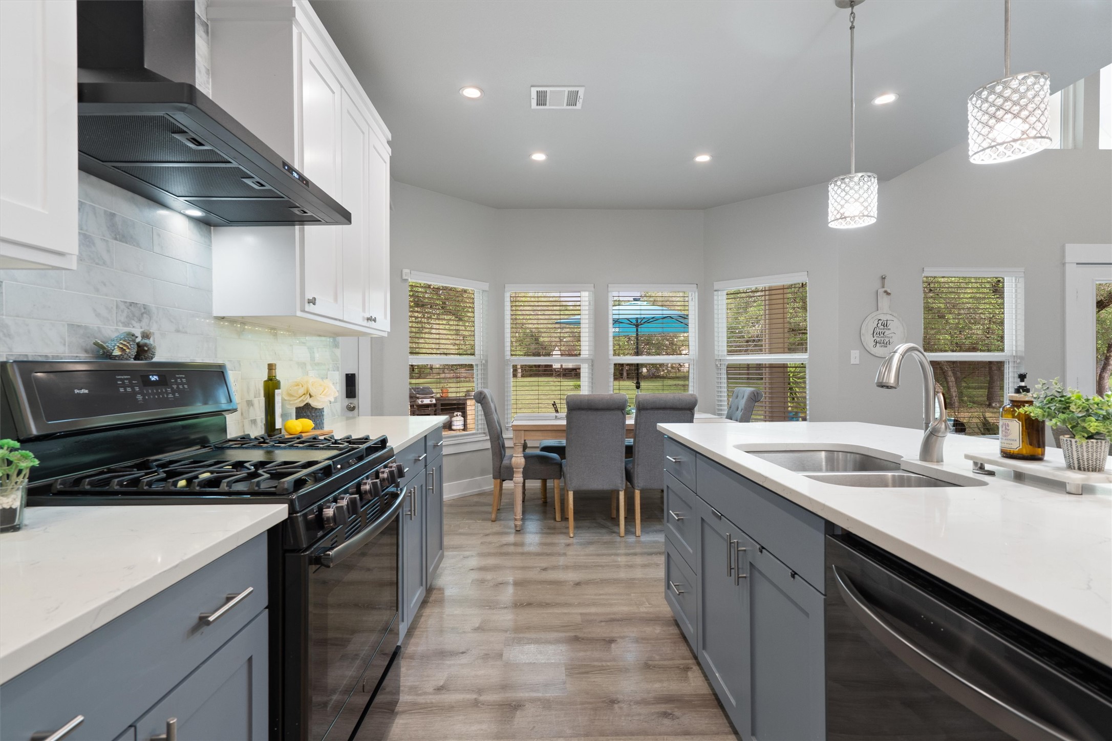 13105 Rooster Springs Road Austin, TX 78737 - Photo 6 of 38 The kitchen features white upper cabinetry, gray base cabinetry, white countertops, and a full suite of black stainless steel appliances