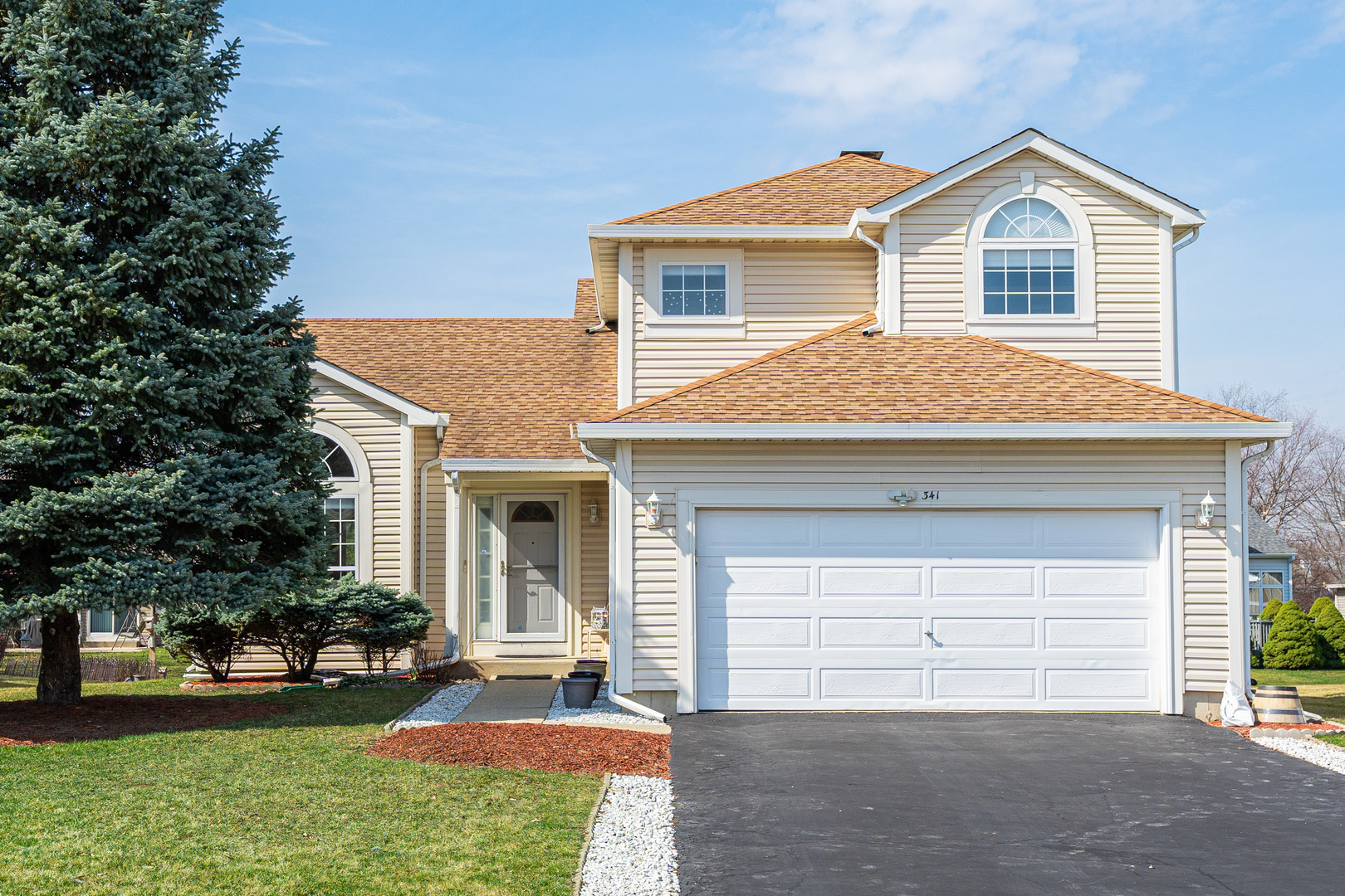 a front view of a house with a yard and garage