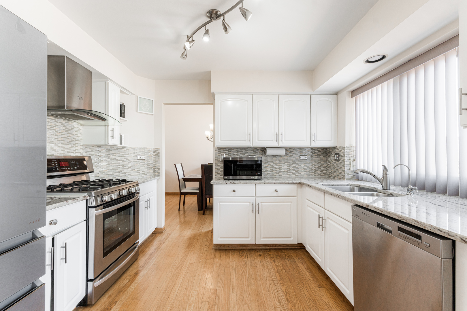 341 Sundance Drive Bartlett, IL 60103 - Photo 10 of 40 a kitchen with stainless steel appliances granite countertop a stove a sink and white cabinets