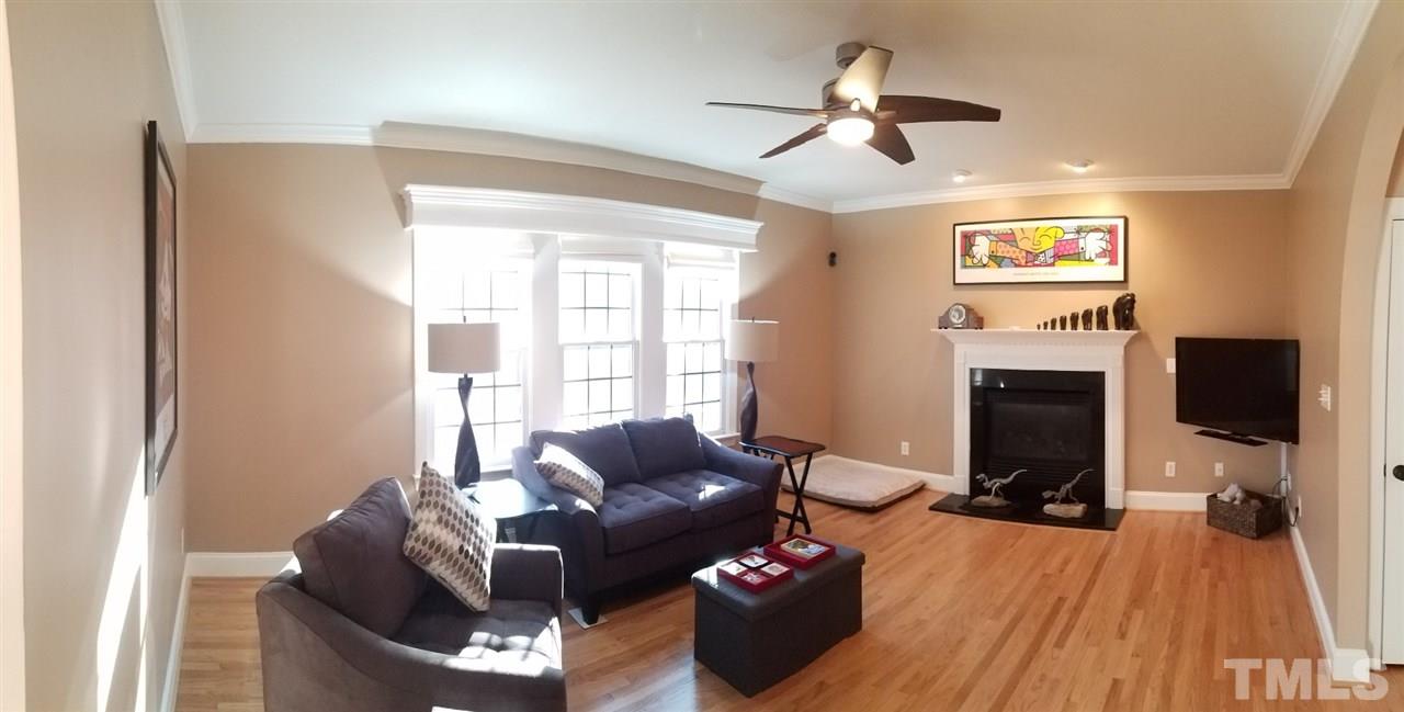 6613 Mafolie Court Raleigh, NC 27613 - Photo 3 of 8 a living room with furniture a fireplace and a flat screen tv