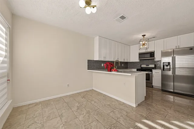 a kitchen with cabinets stainless steel appliances and a counter space