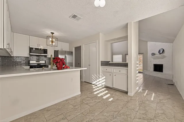 a kitchen with granite countertop white cabinets sink and window