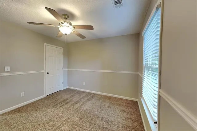 a view of an empty room and a fan