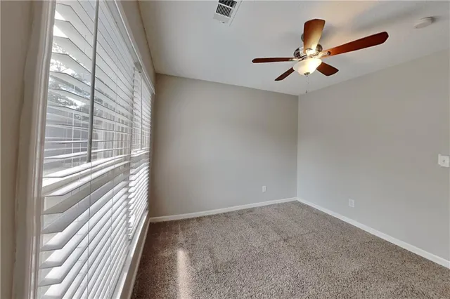 a view of a livingroom with a ceiling fan and window