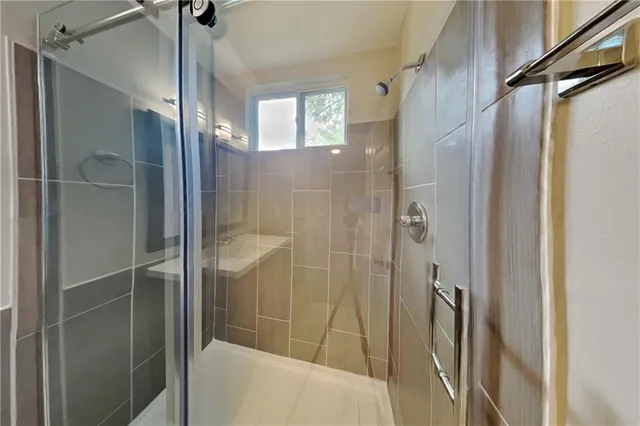 a bathroom with a shower and a glass door
