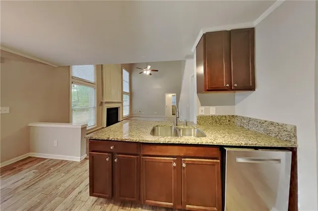 a kitchen with kitchen island granite countertop a sink cabinets and wooden floor