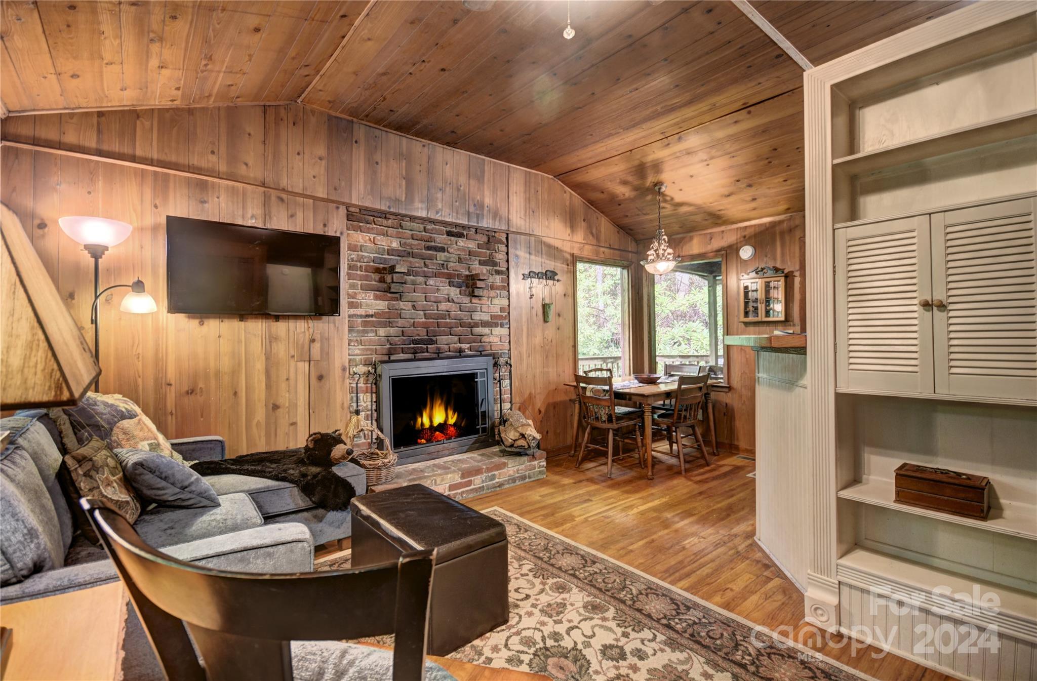 367 Johnson Branch Road Maggie Valley, NC 28751 - Photo 4 of 28 a living room with furniture a flat screen tv and a fireplace