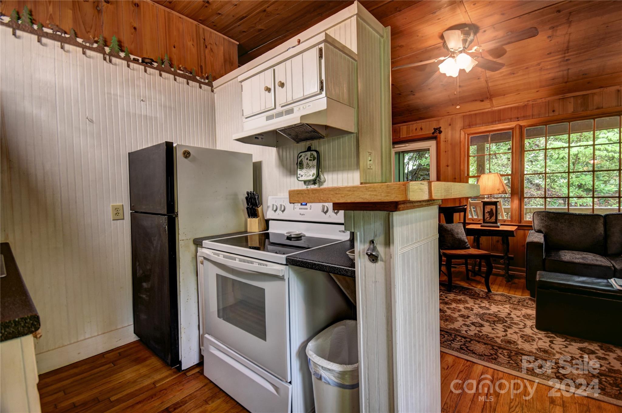367 Johnson Branch Road Maggie Valley, NC 28751 - Photo 9 of 28 a kitchen with stainless steel appliances granite countertop a stove a refrigerator and a dining table