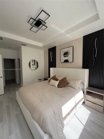 a bedroom with a large bed and a chandelier