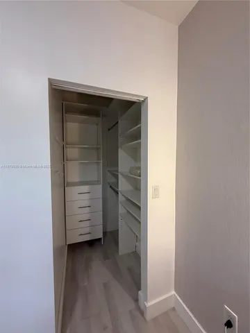 a view of walk in closet with clothes