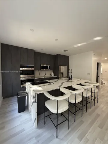 a kitchen with a table chairs and a wooden floor