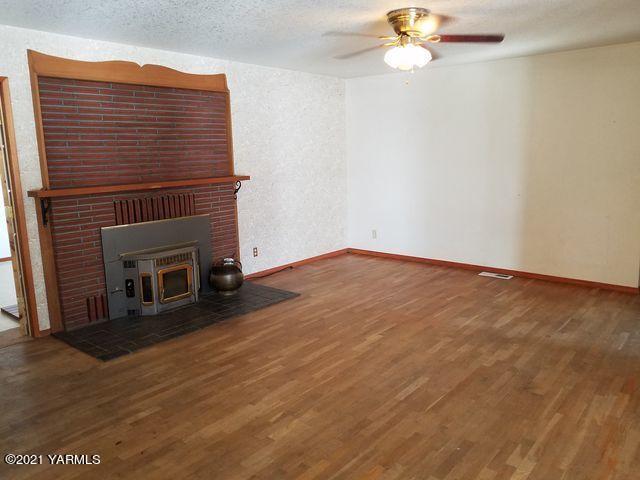 501 Mohar Road Grandview, WA 98930 - Photo 11 of 24 a view of empty room with wooden floor and fireplace