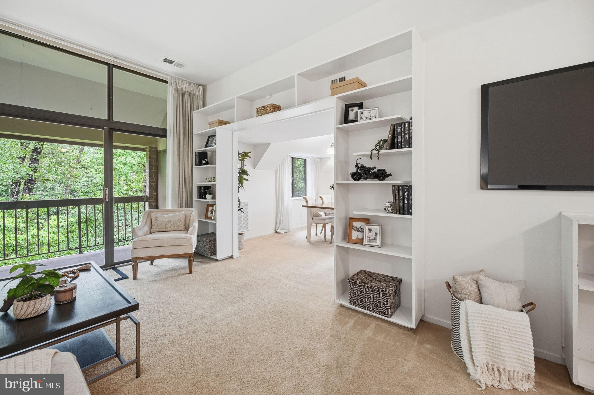 1659 Parkcrest Circle, Unit C Reston, VA 20190 - Photo 13 of 31 a living room with furniture a flat screen tv and a floor to ceiling window