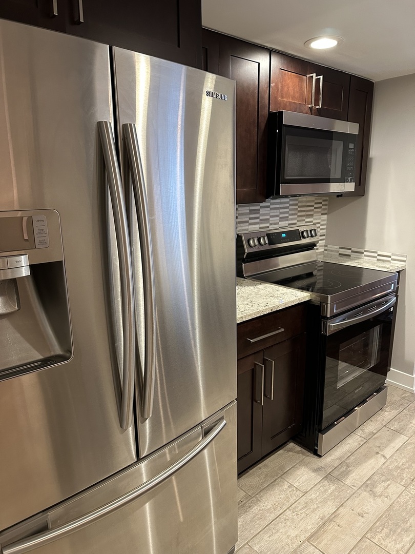 9830 Sayre Avenue, Unit 13 Chicago Ridge, IL 60415 - Photo 16 of 34 a kitchen with stainless steel appliances a refrigerator stove and microwave