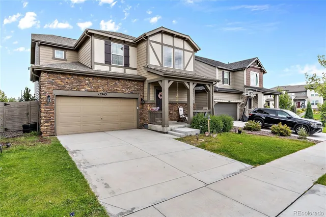 a front view of a house with a garden and trees