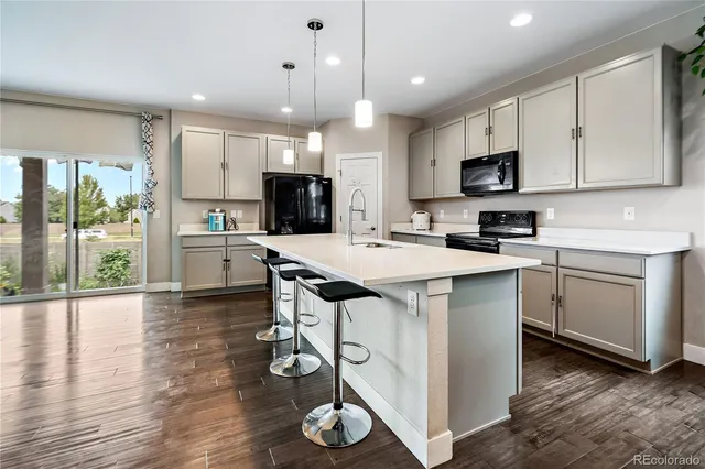 a kitchen with white cabinets stainless steel appliances and wooden floor